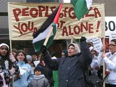 Một phụ nữ cầm cờ Palestine trong một cuộc biểu tình chống Israel ở Toronto.